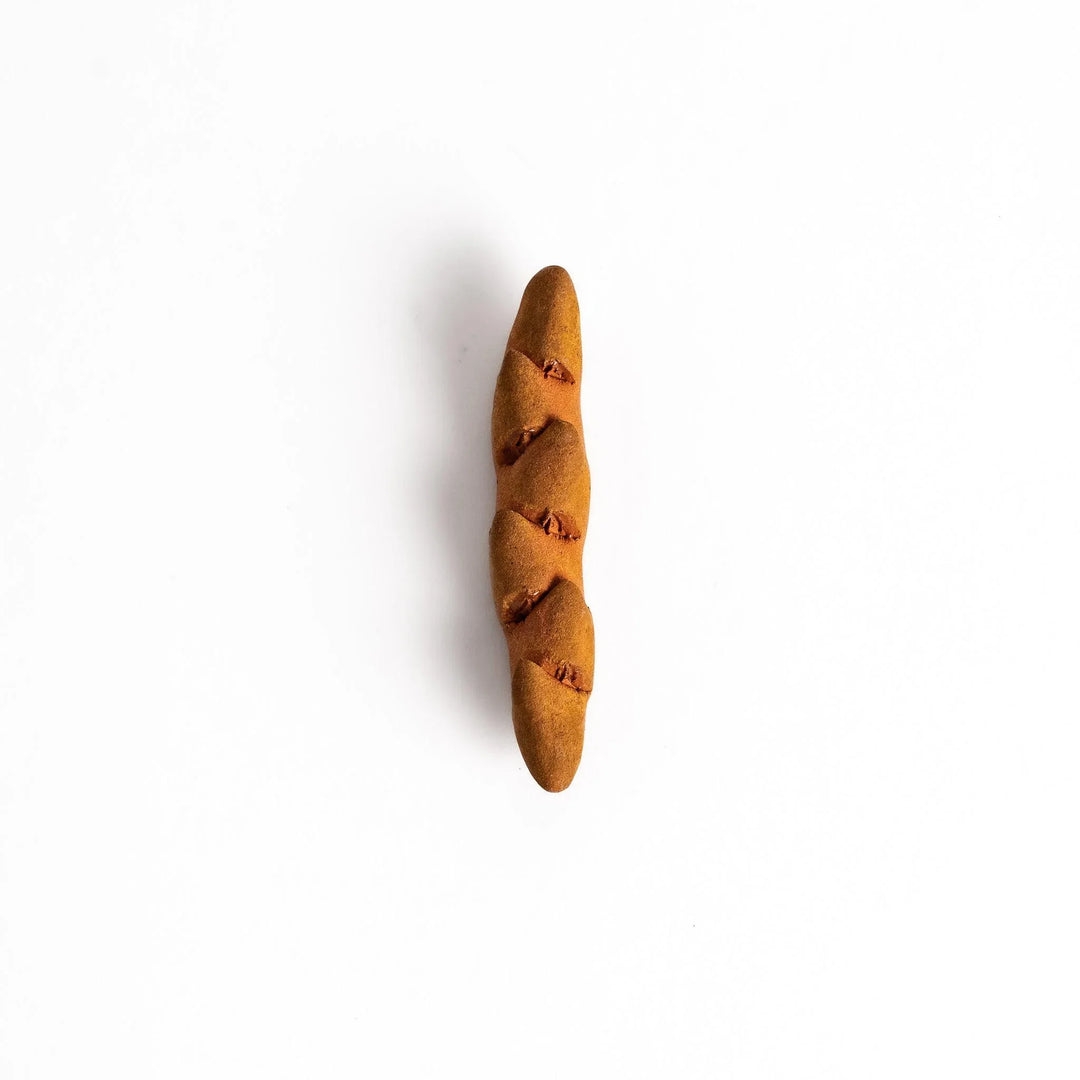 Epi bread shaped chopstick rest with warm brown glaze and detailed texture bringing bakery charm.