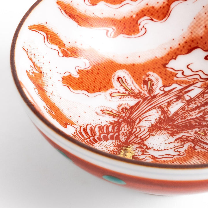 Delicate sake cup adorned with a red, accented by soft swirling clouds, creating a beautiful, traditional Japanese motif.