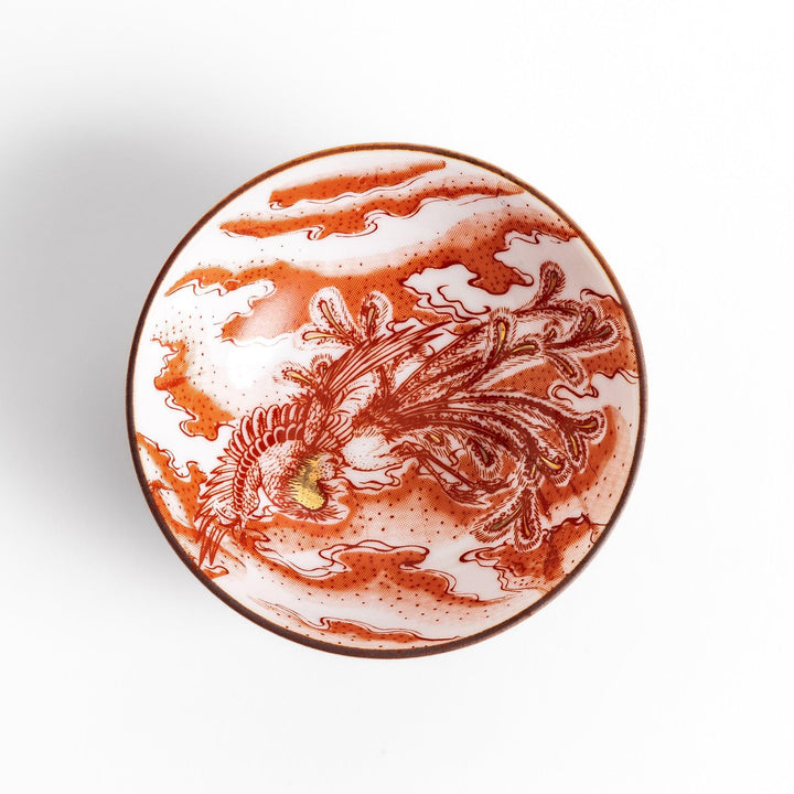 Delicate sake cup adorned with a red, accented by soft swirling clouds, creating a beautiful, traditional Japanese motif.