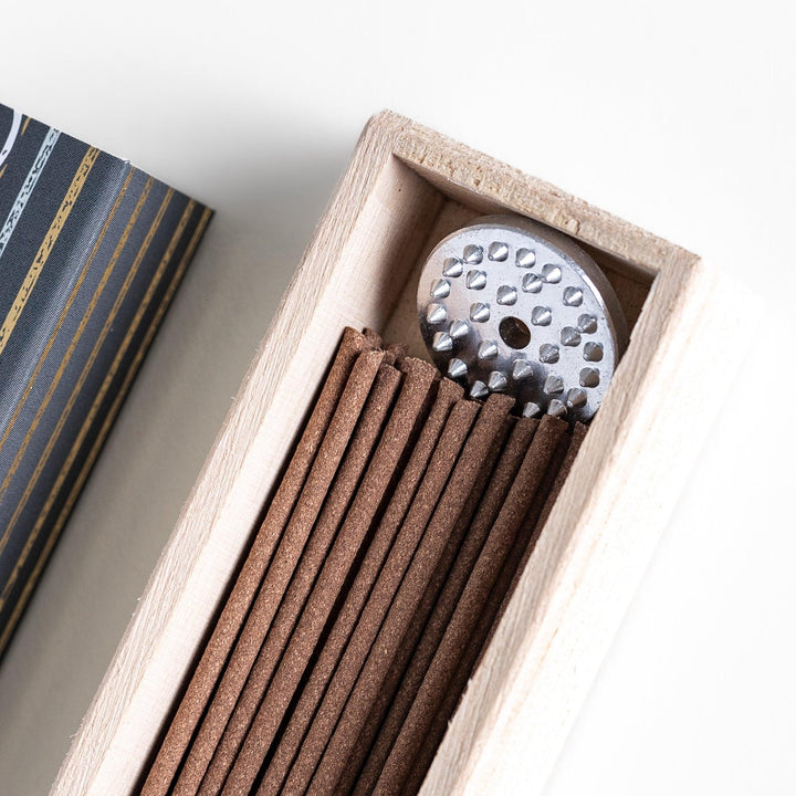 Japanese agarwood incense sticks in a wooden box with an elegant dark patterned sleeve from Kyoto’s Kousaido