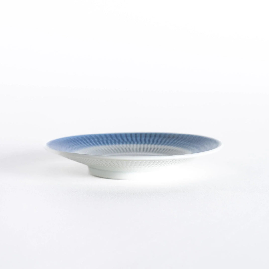 Side view of the blue dessert plate, displaying its sleek profile and rounded edges.
