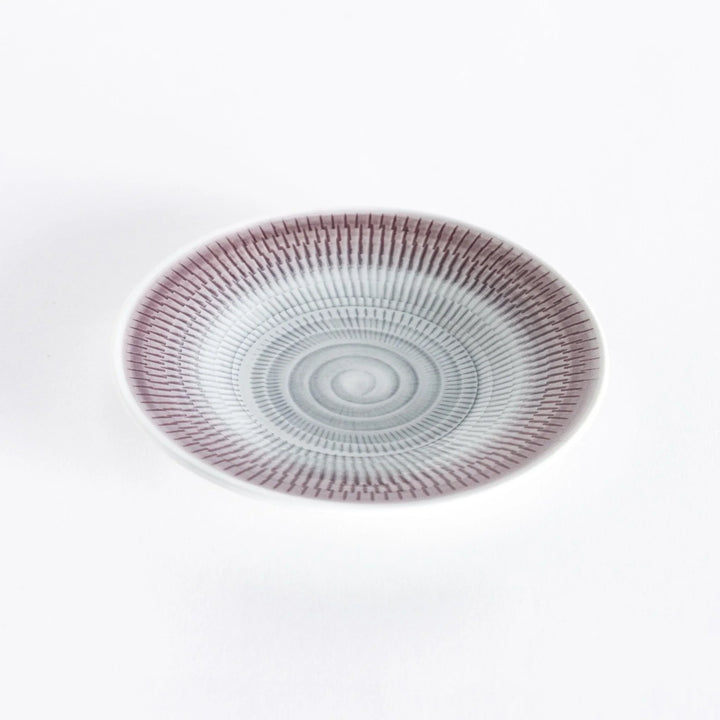 Light purple dessert plate with elegant spiral-striped patterns, photographed from a slight angle.