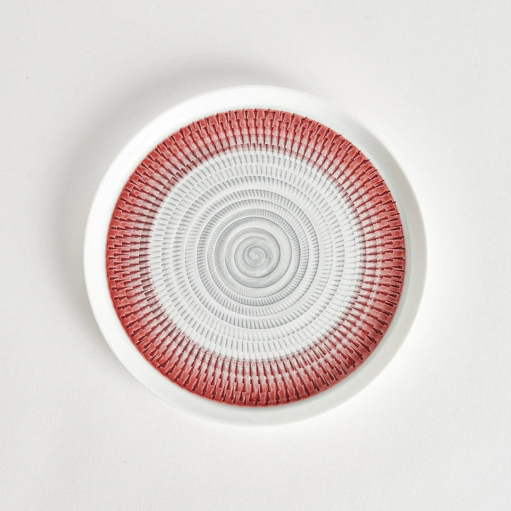 Top view of a plate featuring a red spiral pattern on a white background.