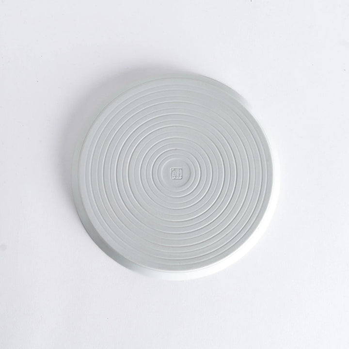 Bottom view of the plate, revealing a clean white surface with a small maker’s mark at the center.