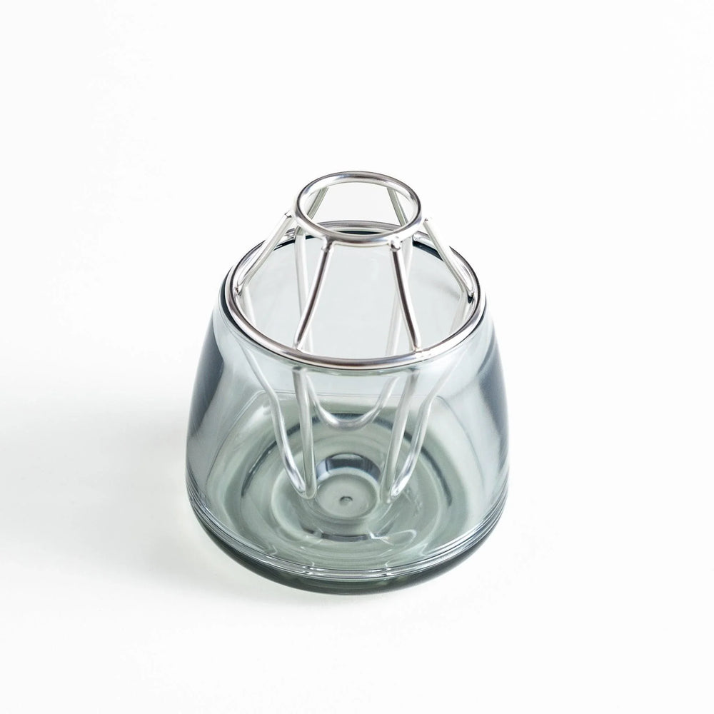 Glass vase with a silver-colored frame on top. The frame has a unique geometric design.