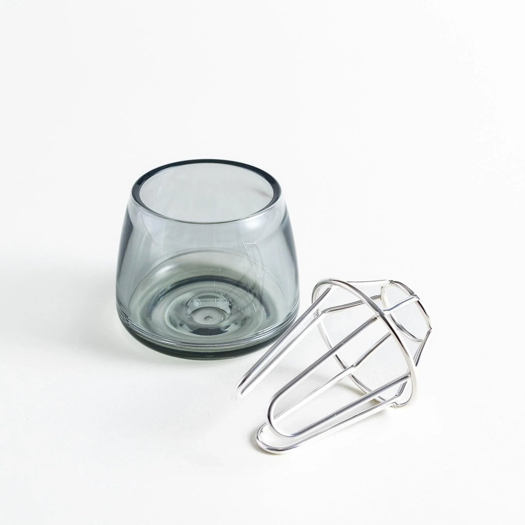 Glass vase with silver frame lying beside it, showing both components separately.