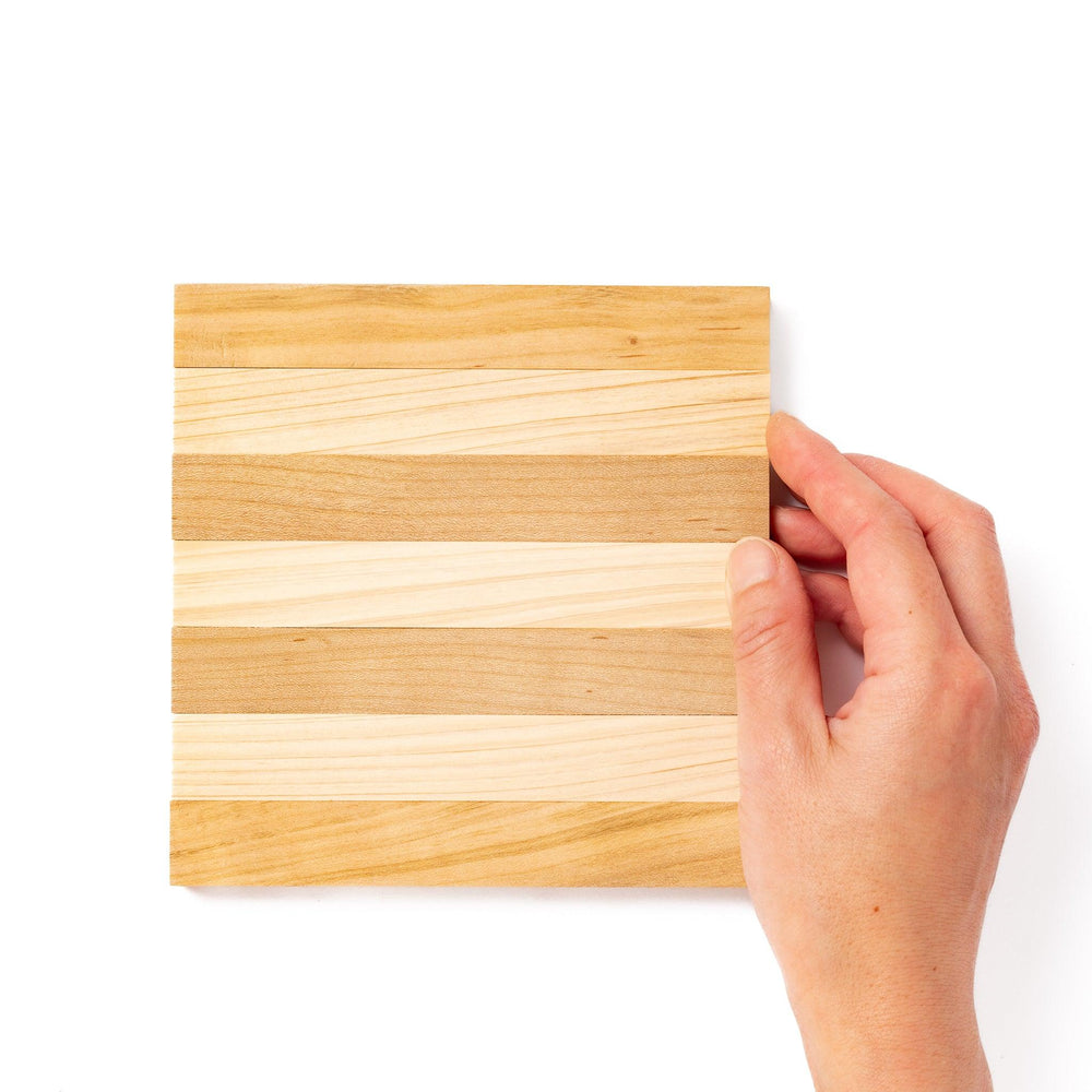 Expandable hinoki and cherry wood trivet with slats fanned out, showing mixed wood tones for versatile pot support