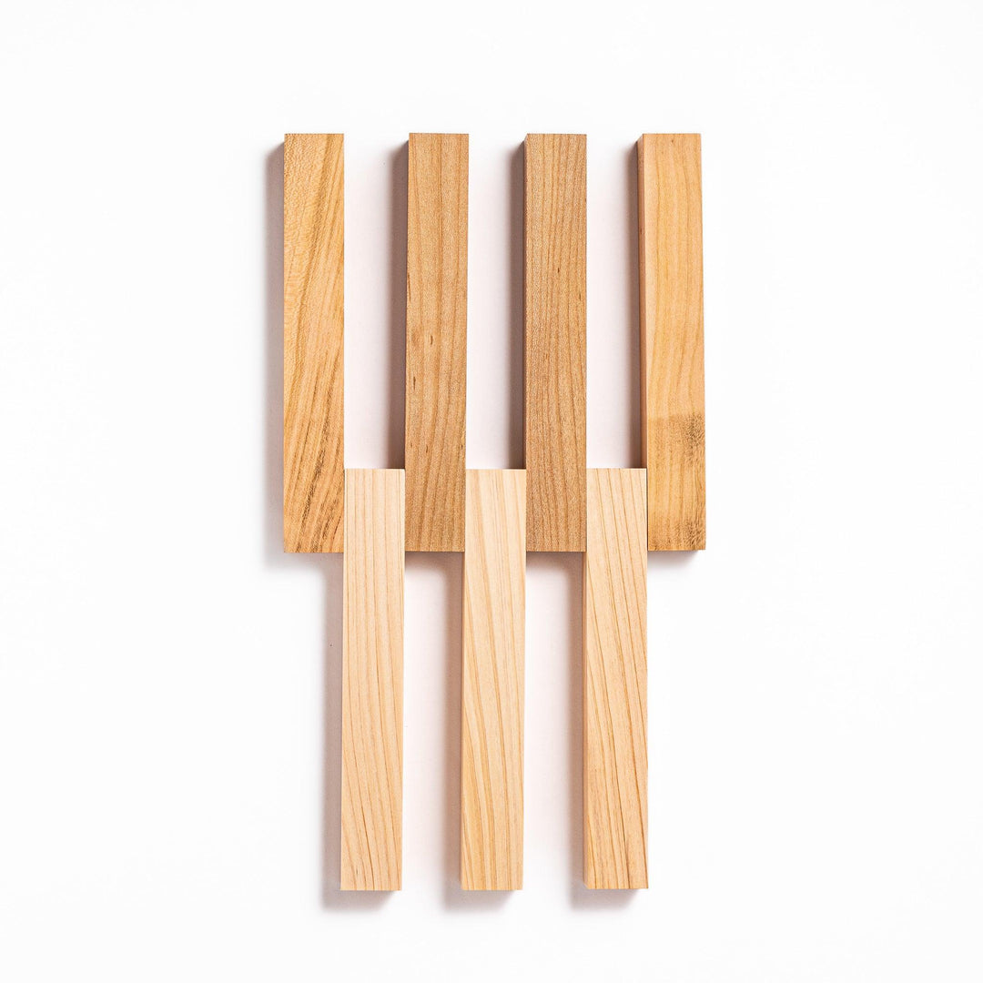 Expandable hinoki and cherry wood trivet with slats fanned out, showing mixed wood tones for versatile pot support