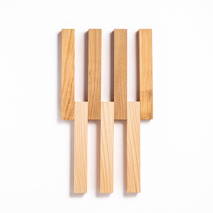 Expandable hinoki and cherry wood trivet with slats fanned out, showing mixed wood tones for versatile pot support