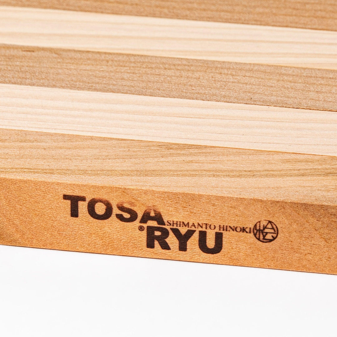 Expandable hinoki and cherry wood trivet with slats fanned out, showing mixed wood tones for versatile pot support