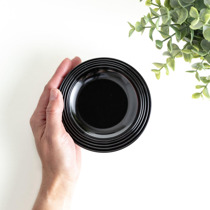 Set of five nested lacquer bowls used in Japanese oryoki meals representing minimalism mindfulness in black or red.