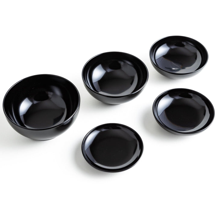 Set of five nested lacquer bowls used in Japanese oryoki meals representing minimalism mindfulness in black or red.