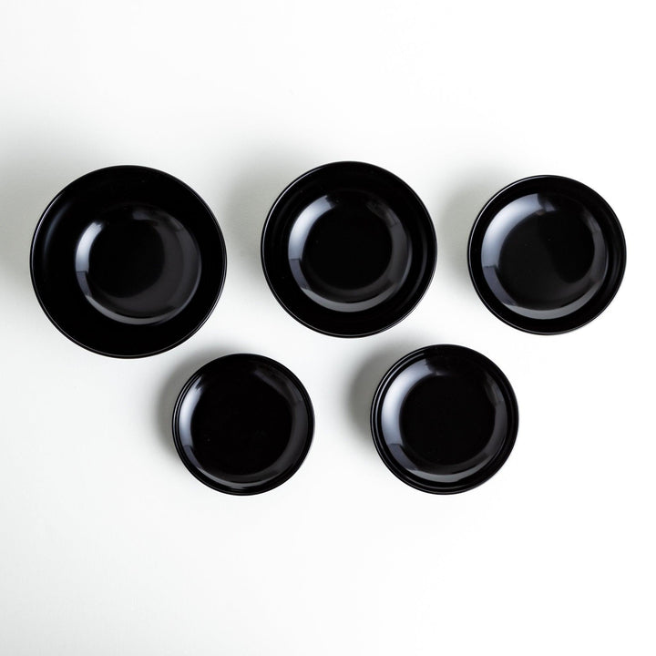 Set of five nested lacquer bowls used in Japanese oryoki meals representing minimalism mindfulness in black or red.