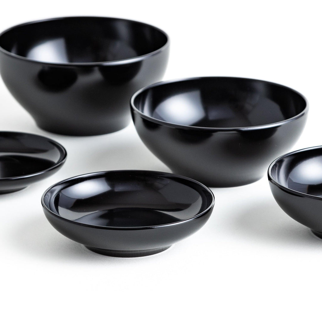 Set of five nested lacquer bowls used in Japanese oryoki meals representing minimalism mindfulness in black or red.