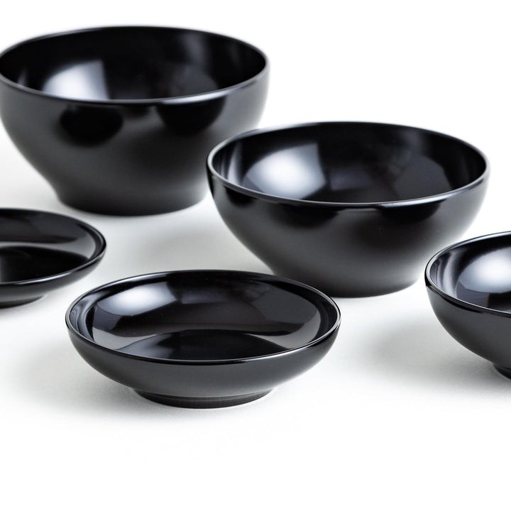 Set of five nested lacquer bowls used in Japanese oryoki meals representing minimalism mindfulness in black or red.