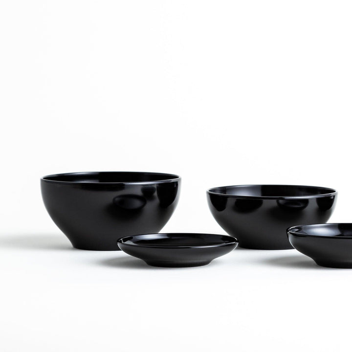 Set of five nested lacquer bowls used in Japanese oryoki meals representing minimalism mindfulness in black or red.