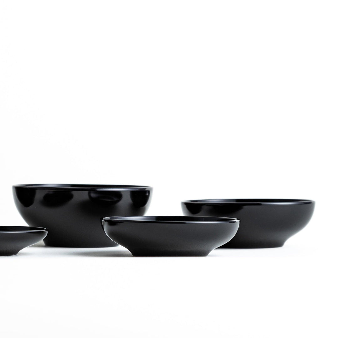 Set of five nested lacquer bowls used in Japanese oryoki meals representing minimalism mindfulness in black or red.