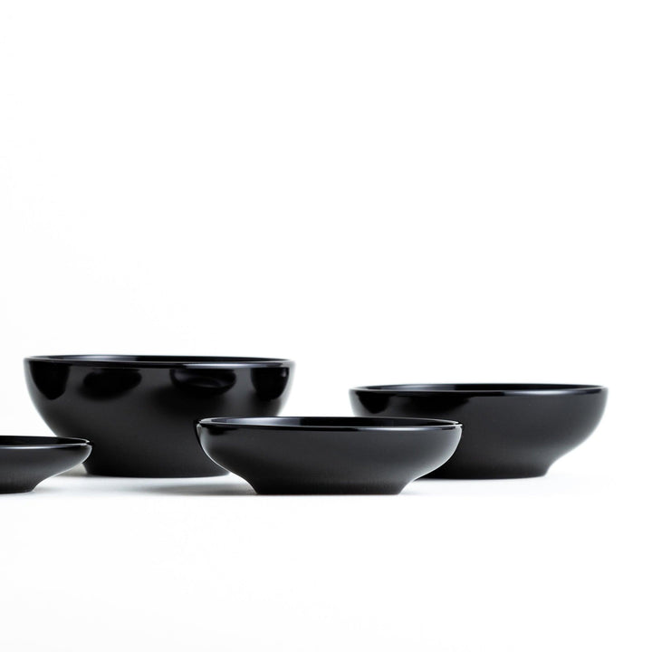 Set of five nested lacquer bowls used in Japanese oryoki meals representing minimalism mindfulness in black or red.