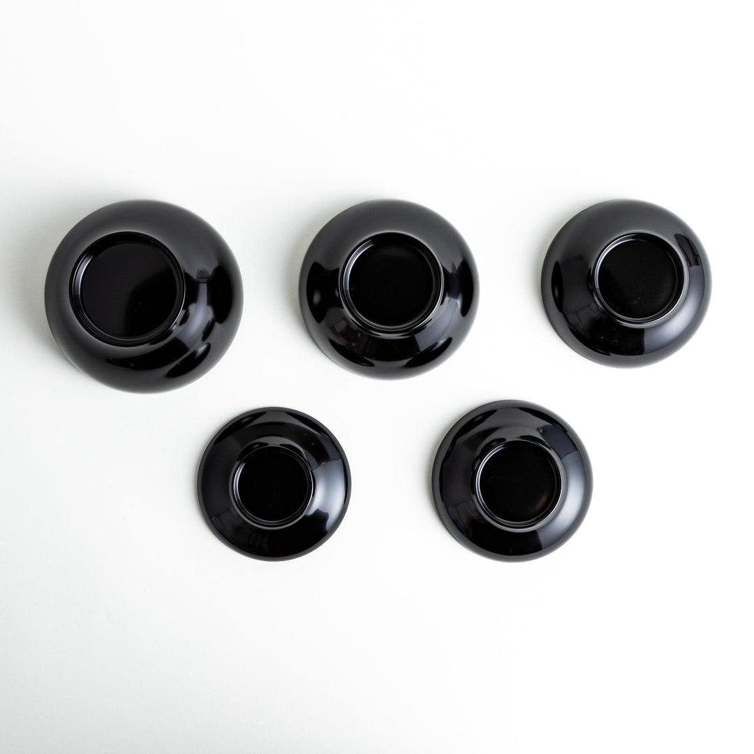 Set of five nested lacquer bowls used in Japanese oryoki meals representing minimalism mindfulness in black or red.