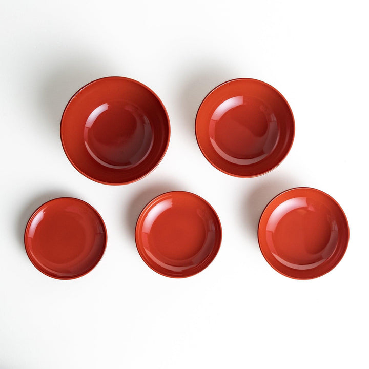 Set of five nested lacquer bowls used in Japanese oryoki meals representing minimalism mindfulness in black or red.