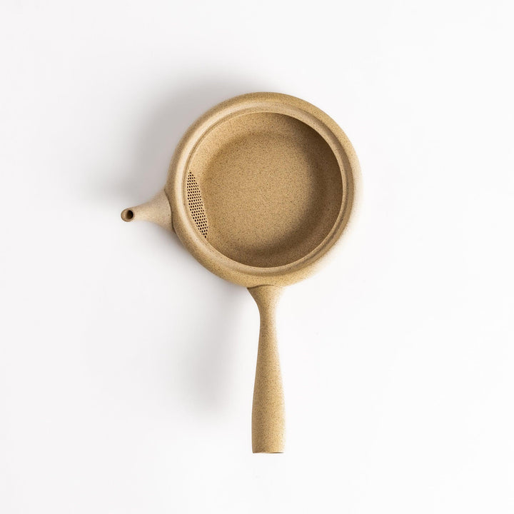 Sleek beige teapot with flat body and side handle offering minimalist design for refined tea serving.