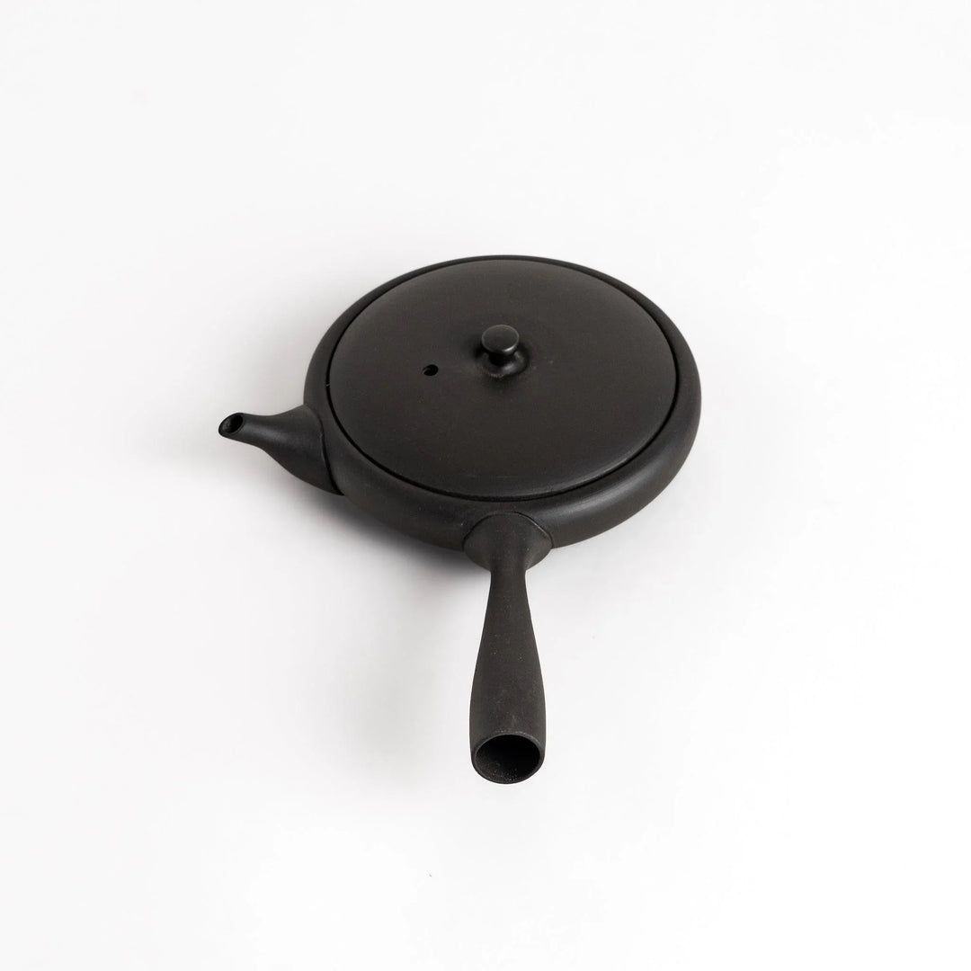 Sleek black teapot with flat body and side handle offering minimalist design for elegant Japanese tea.