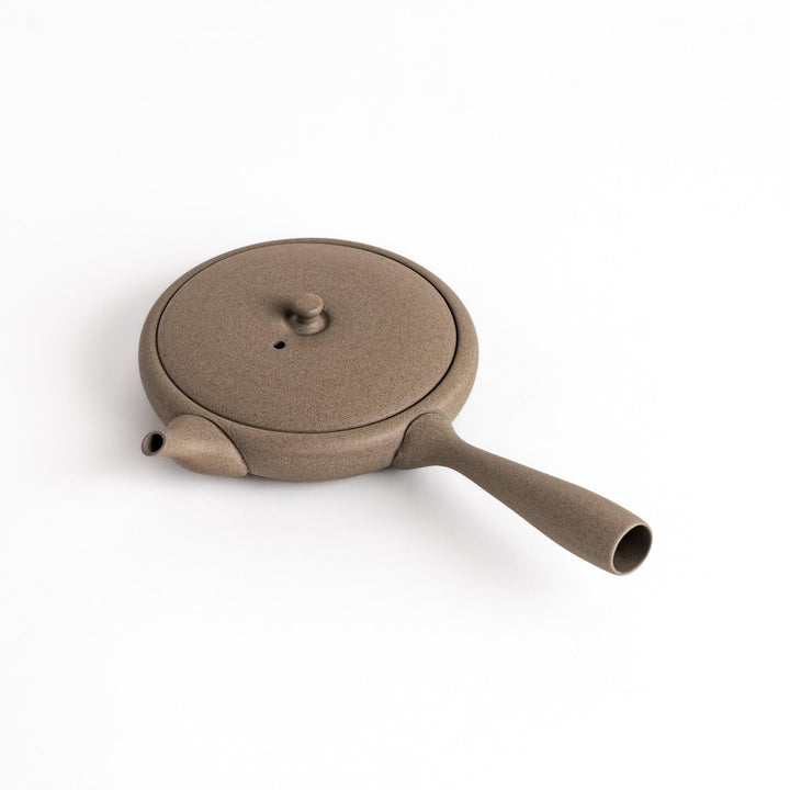 Sleek gray teapot with flat body and side handle offering minimalist aesthetic for modern tea setting.