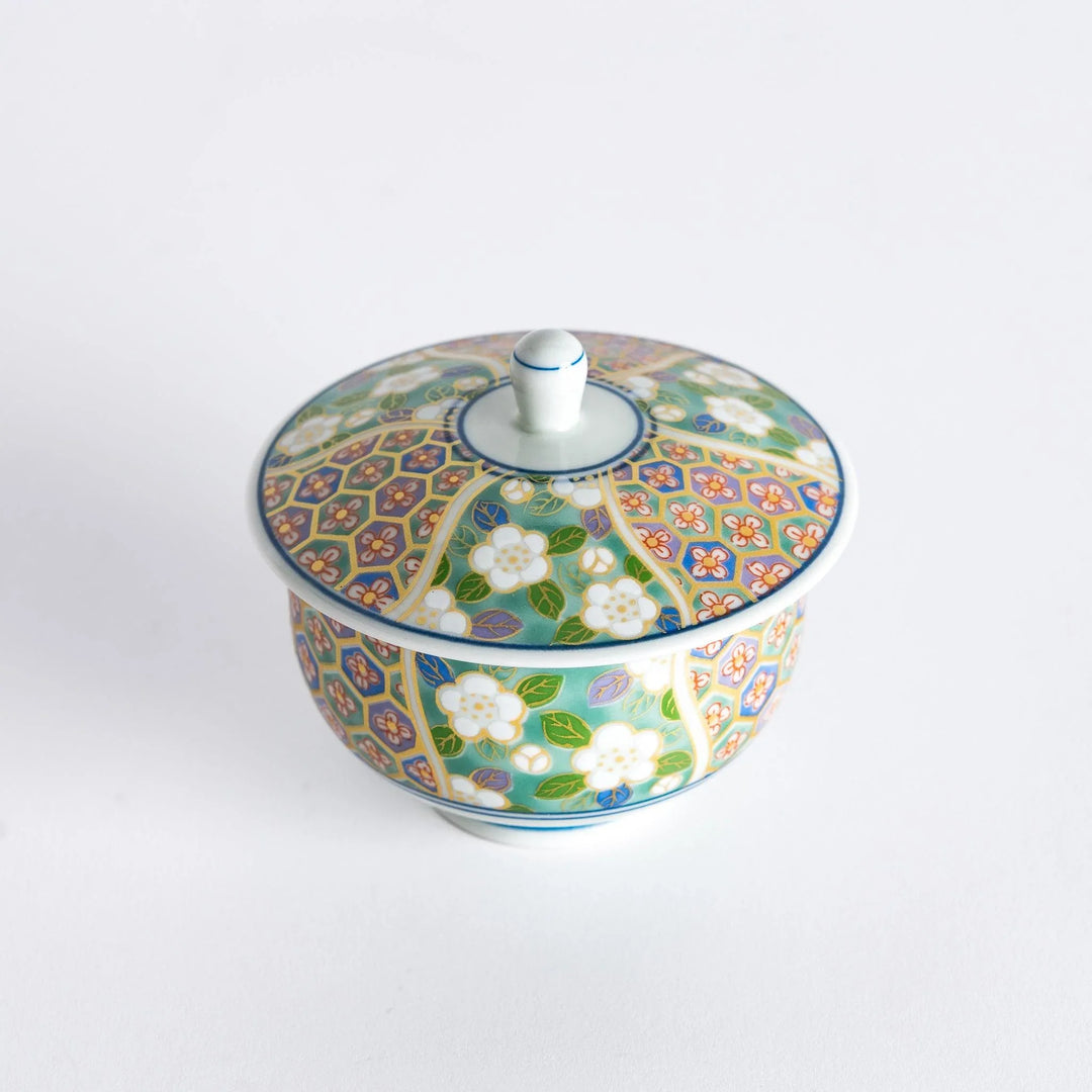 Top view of tea cup featuring a floral design with green and pink tones.