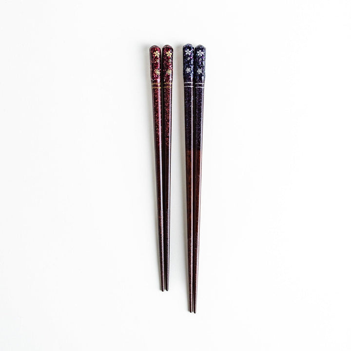 A pair of chopsticks with a sleek design featuring glitter accents and small floral patterns in deep red and navy blue, adding a touch of sparkle to your dining experience.