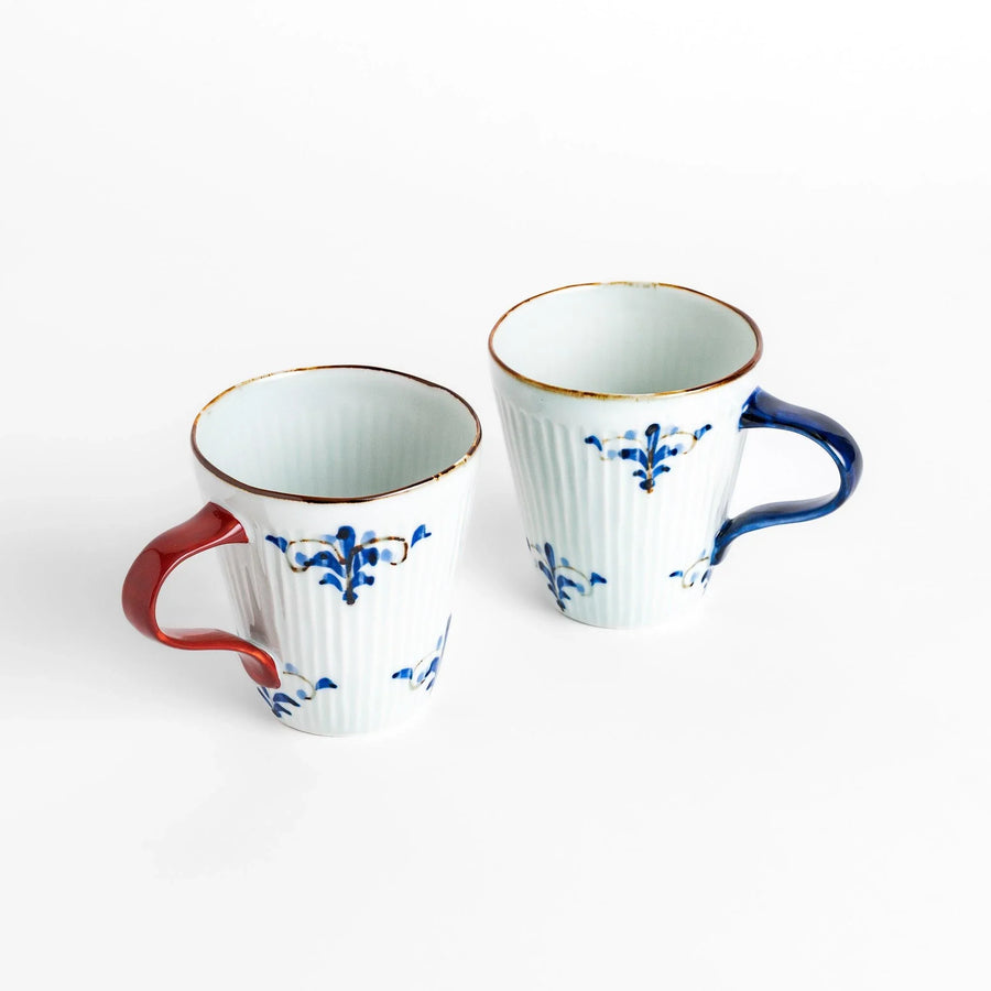 Floral Leaves mug pair with blue and red handles, decorated with blue floral motifs and gold detailing.