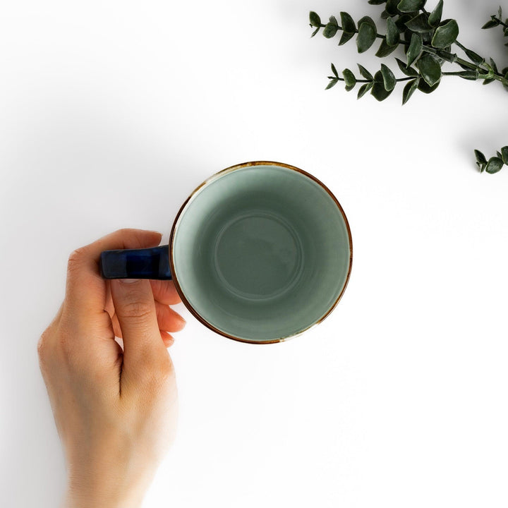 Floral Leaves mug with blue handle, featuring blue floral motifs, ribbed body, and gold trim for a refined look.