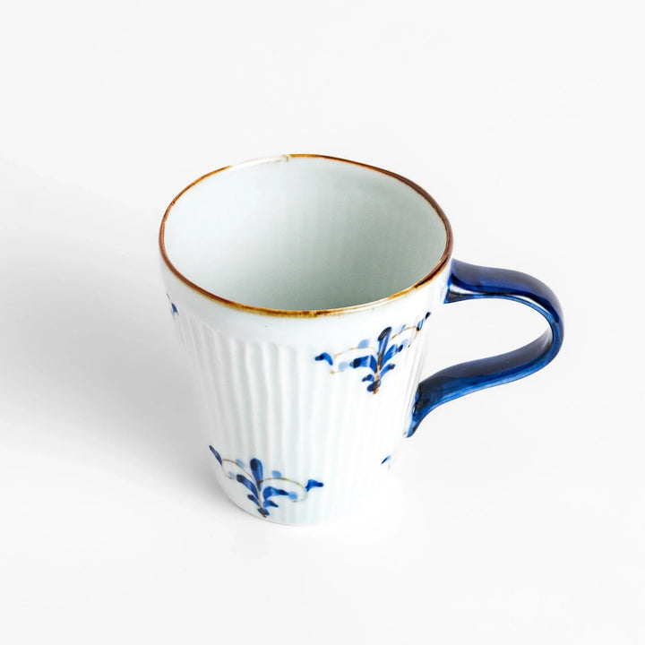 Floral Leaves mug with blue handle, featuring blue floral motifs, ribbed body, and gold trim for a refined look.