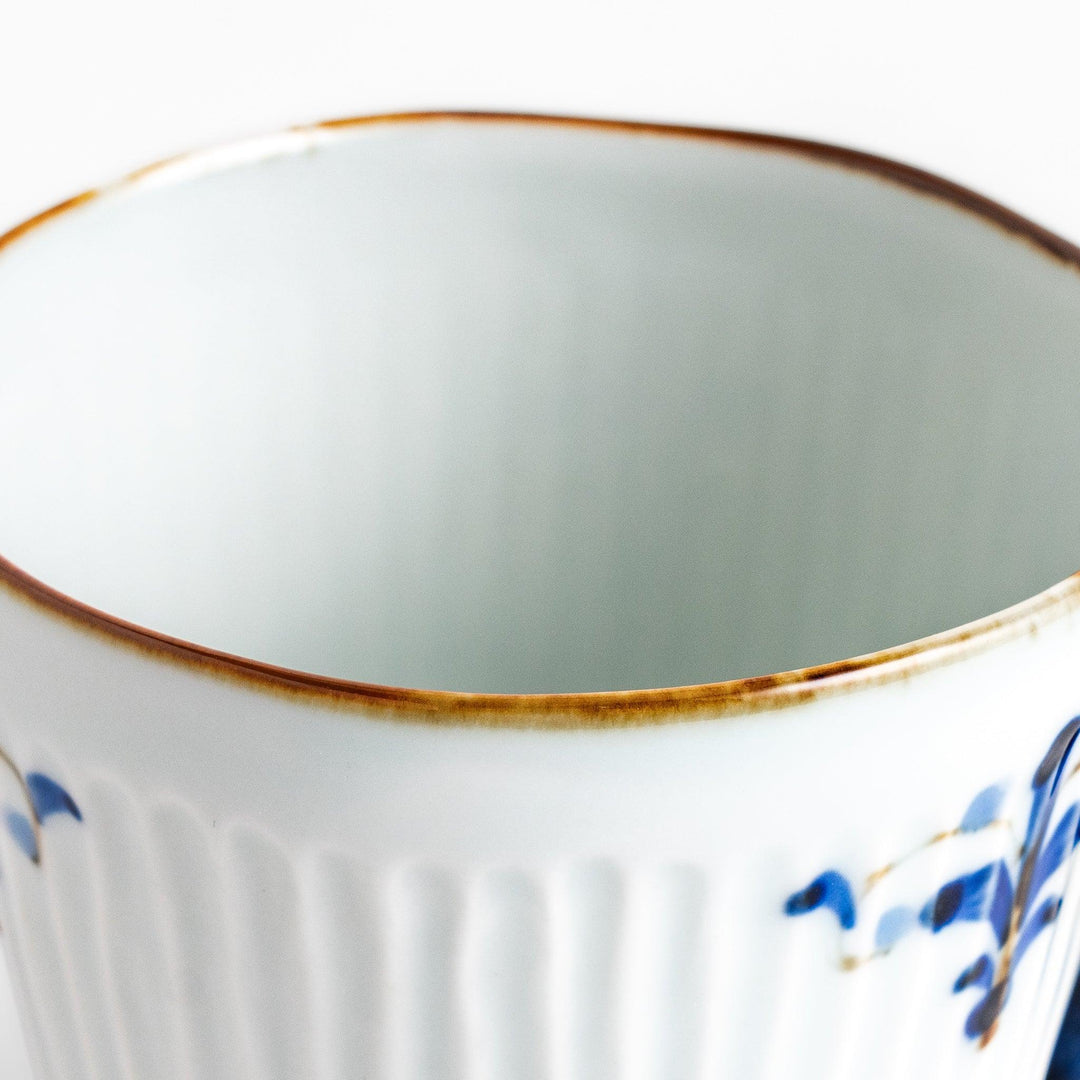 Floral Leaves mug with blue handle, featuring blue floral motifs, ribbed body, and gold trim for a refined look.