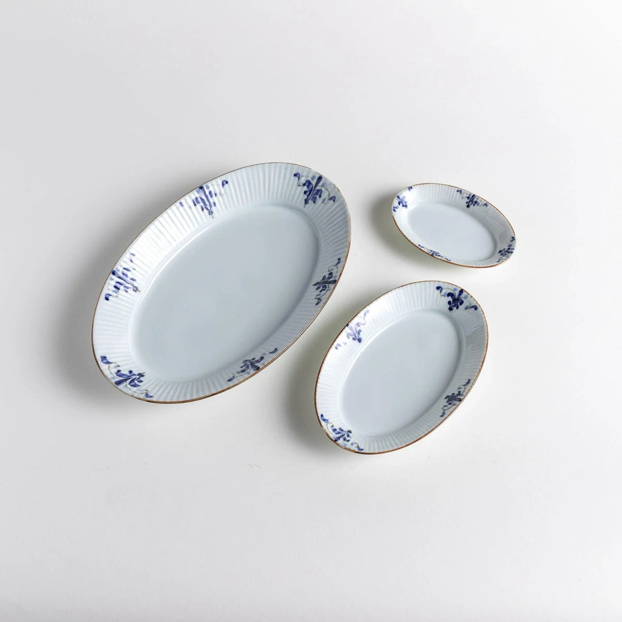 Three piece oval plate set with ridged design and blue floral motifs including large medium and small plates.
