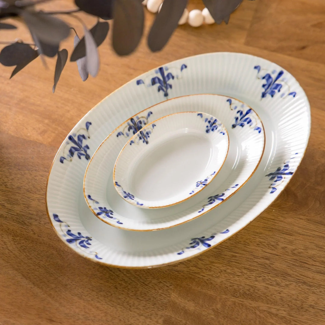 Three piece oval plate set with ridged design and blue floral motifs including large medium and small plates.