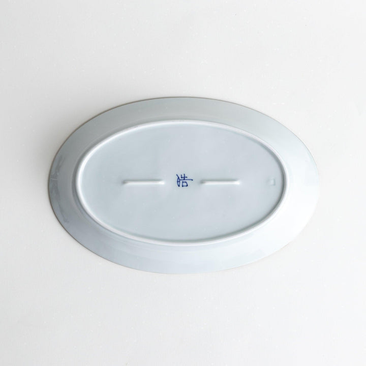 A medium-sized oval porcelain plate adorned with blue floral designs on the edges.