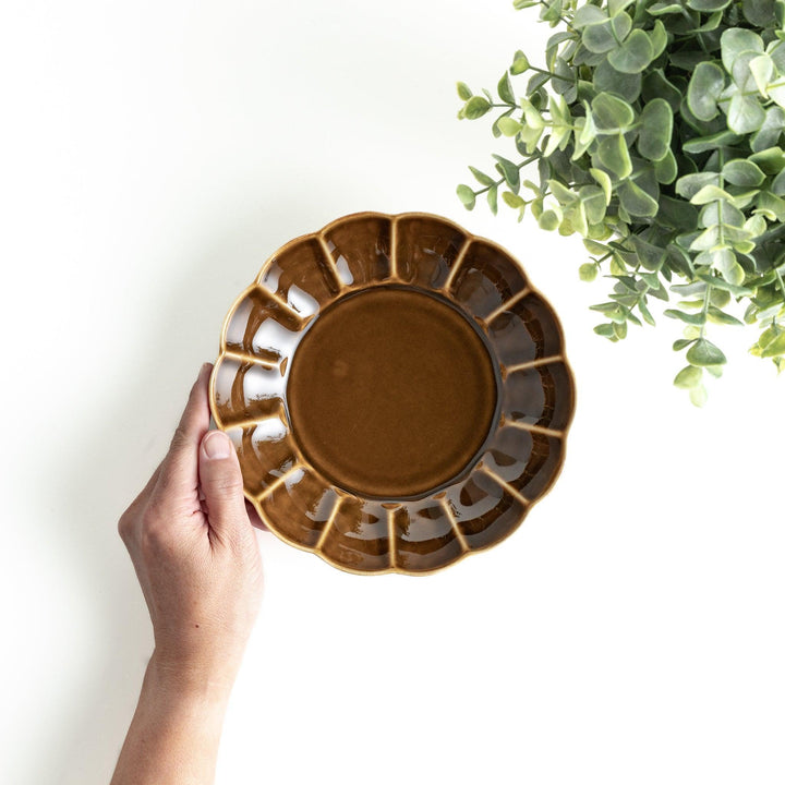 Cereal bowl with scalloped edges and a glossy dark brown or olive finish.