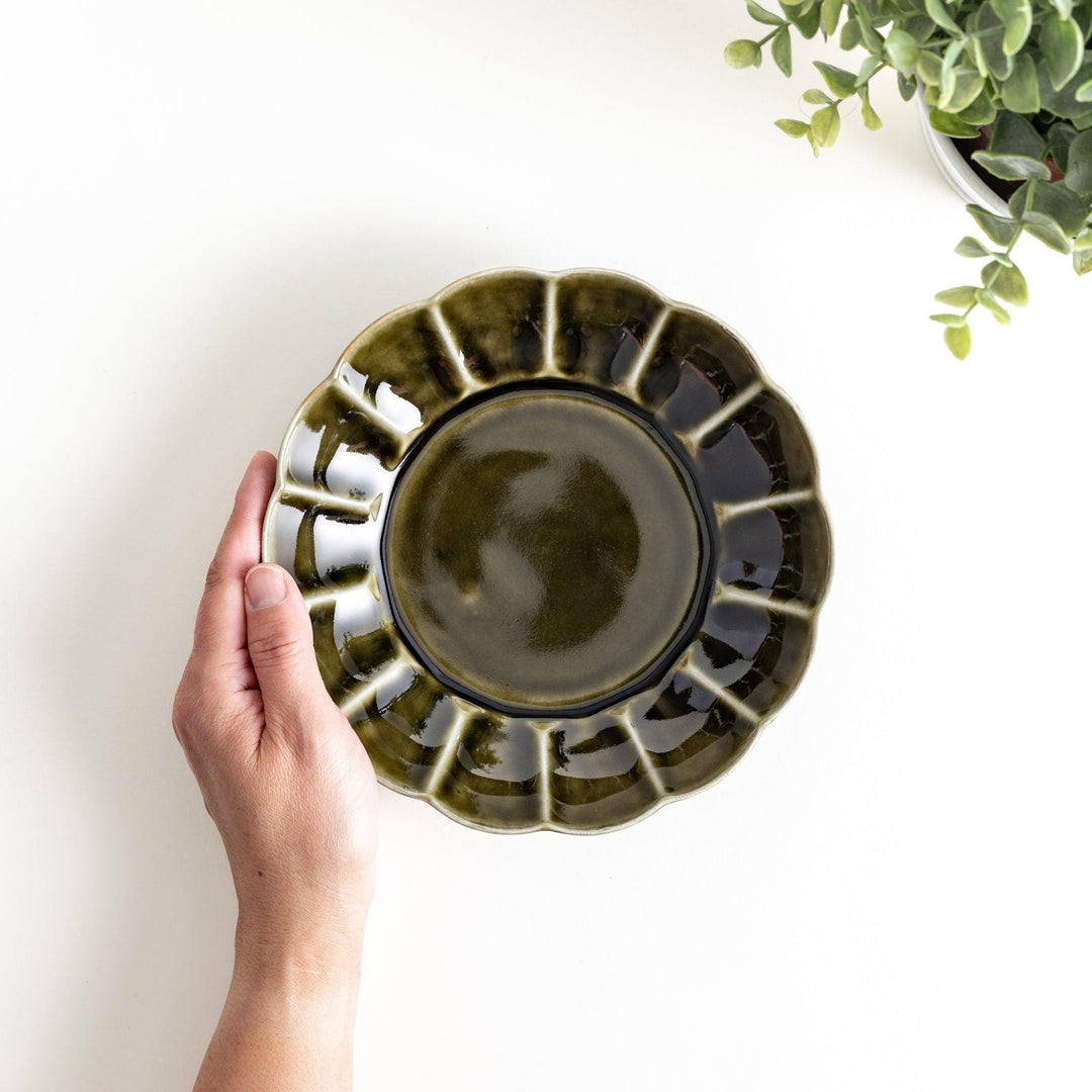 Cereal bowl with scalloped edges and a glossy dark brown or olive finish.