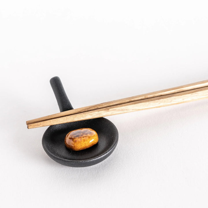 Frying pan hamburger chopstick rest featuring detailed design adding fun and playful touch to dining.