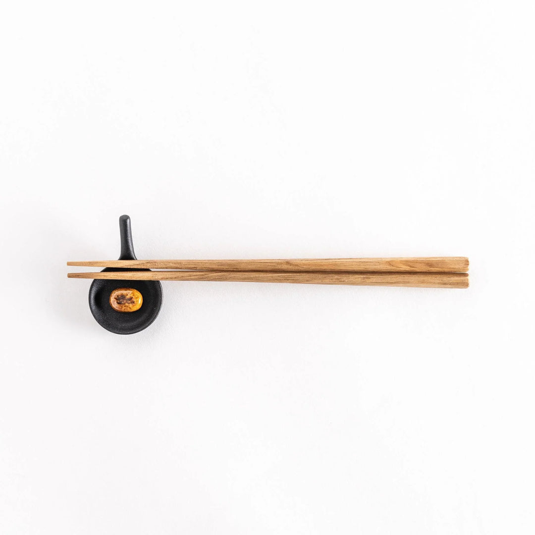 Frying pan hamburger chopstick rest featuring detailed design adding fun and playful touch to dining.