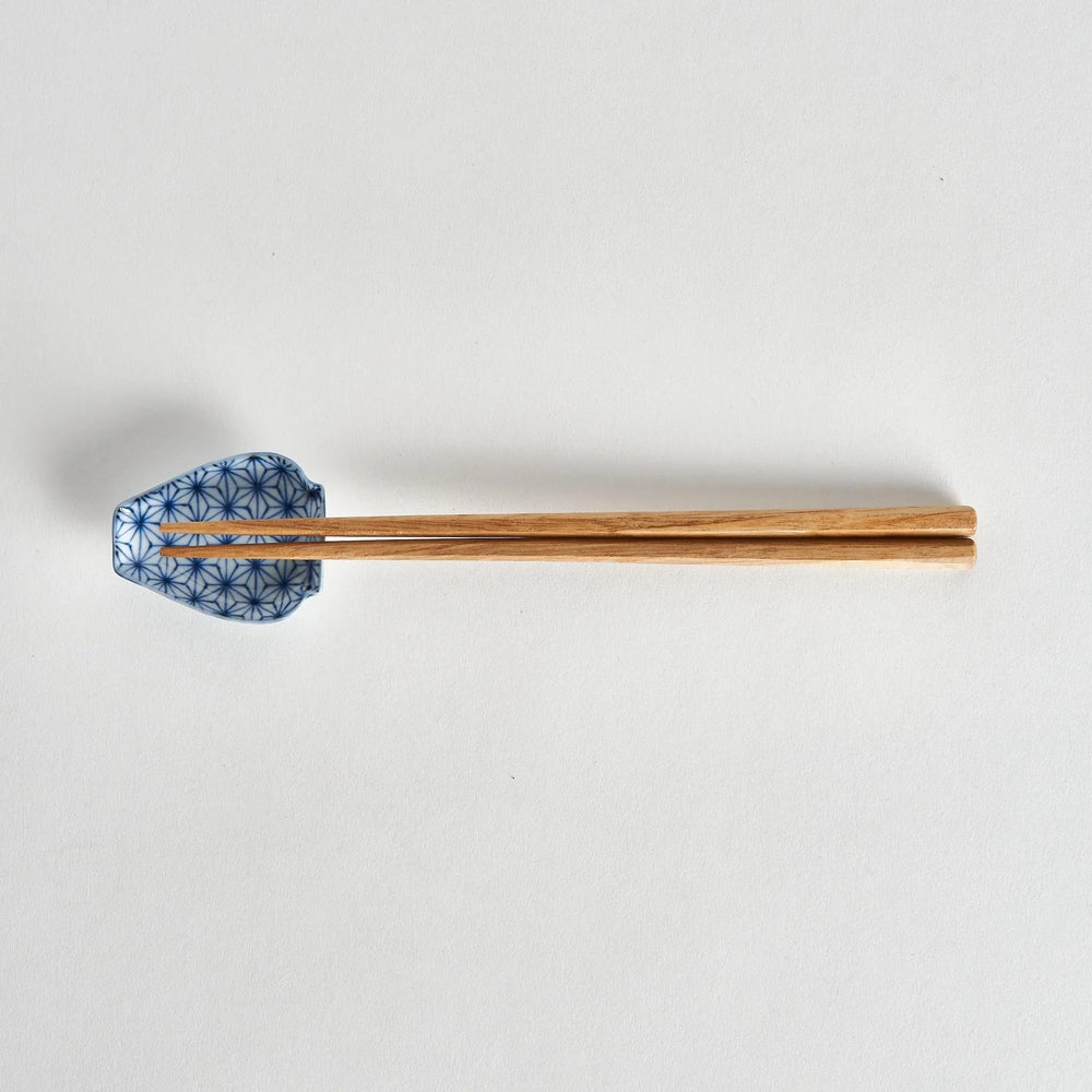 Mini Japanese vase shaped sauce dish with blue geometric flower pattern paired with wooden chopsticks.