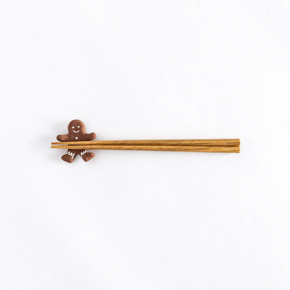 Gingerbread man ceramic chopstick rest adding festive and playful touch to holiday Japanese table setting.