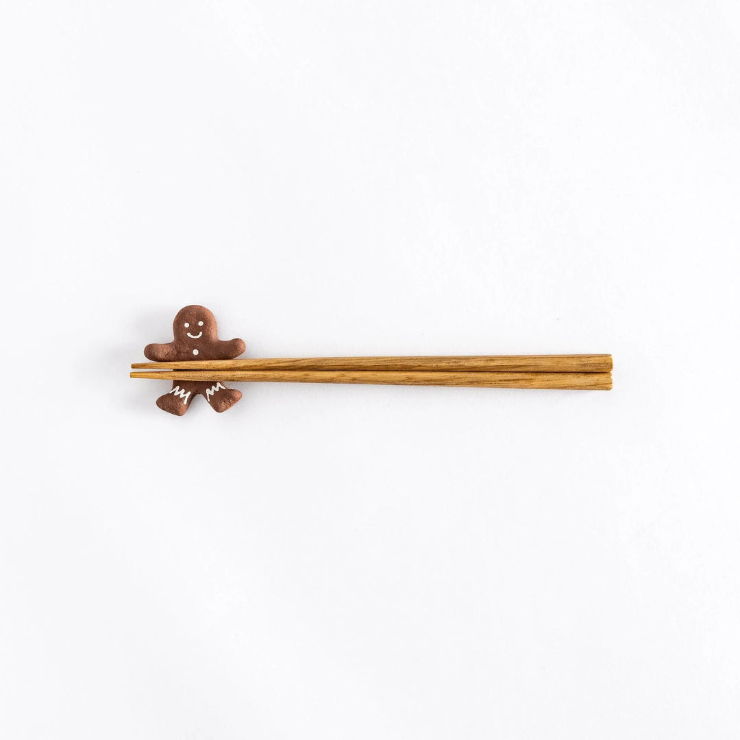 Gingerbread man ceramic chopstick rest adding festive and playful touch to holiday Japanese table setting.