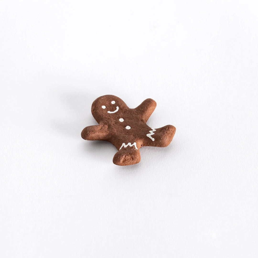 Gingerbread man ceramic chopstick rest adding festive and playful touch to holiday Japanese table setting.