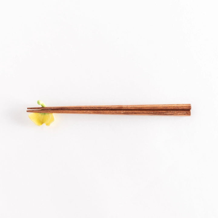 Chopsticks resting on the ginkgo leaf chopsticks rest, full view from above.