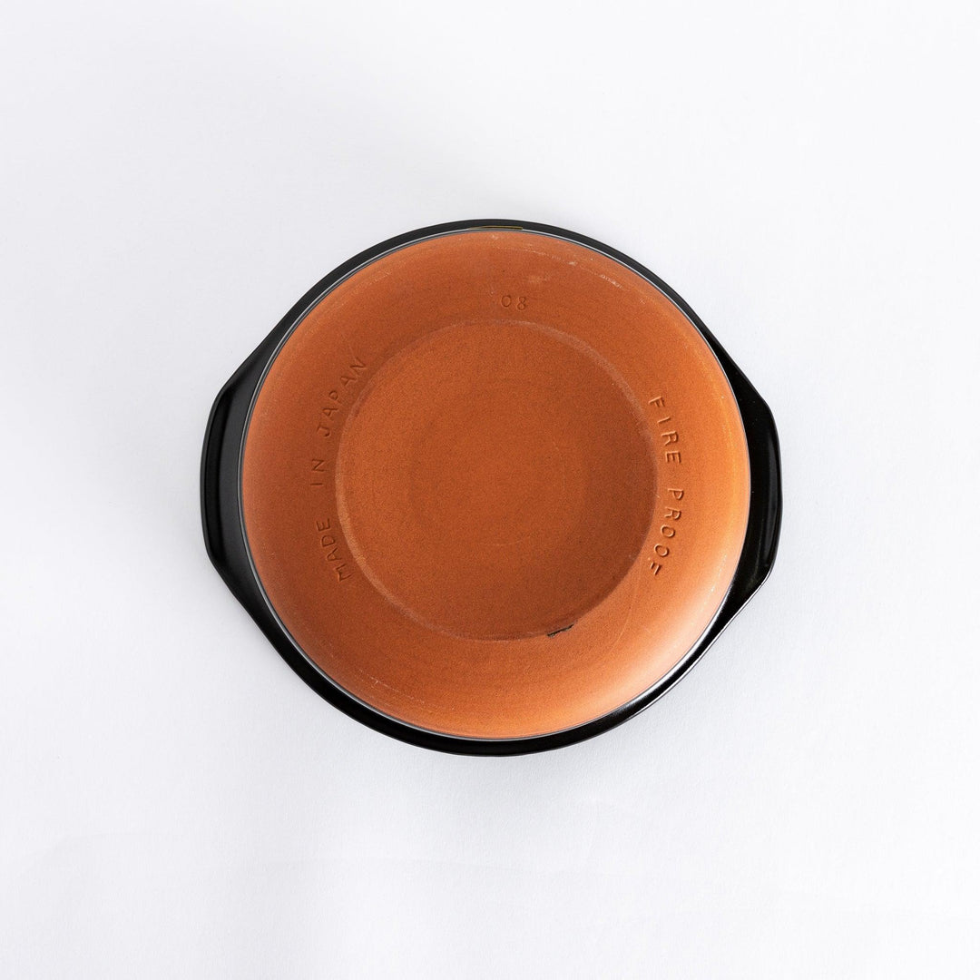 Underside of a blue donabe pot, showing its unglazed ceramic base and durable design.