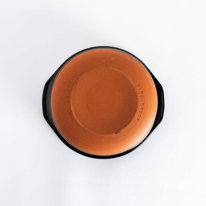 Underside of a blue donabe pot, showing its unglazed ceramic base and durable design.