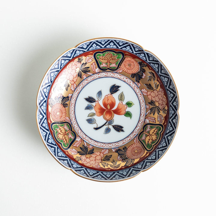 Dessert plate with central floral motif bordered by multicolored patterns and gold blue traditional designs.