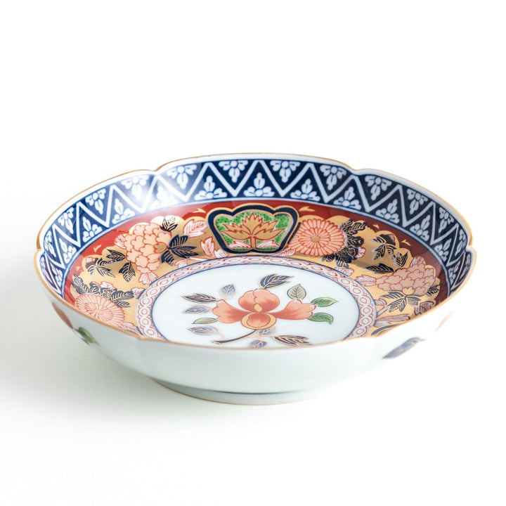 Dessert plate with central floral motif bordered by multicolored patterns and gold blue traditional designs.