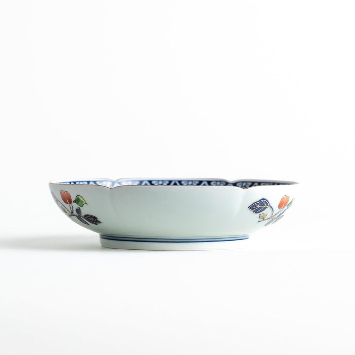 Dessert plate with central floral motif bordered by multicolored patterns and gold blue traditional designs.